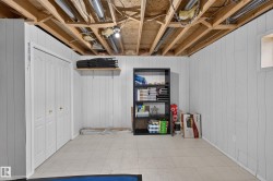 White paneling, bi-fold closet doors, exposed ceiling joists, and a utility window - 