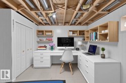 White paneled walls with exposed ceiling joists, white desk with storage drawers, light wood-finish wall-mounted shelving, and bi-fold closet doors - 