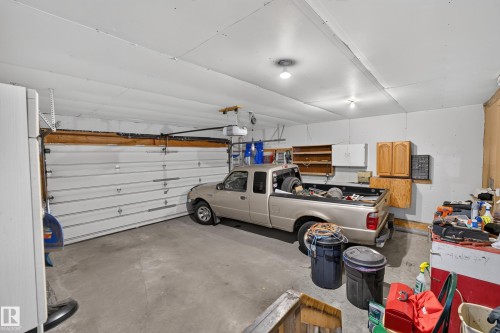 Attached garage featuring a concrete floor, built-in cabinetry, and overhead lighting - 365 Hollick-Kenyon Road Nw, Edmonton, AB 