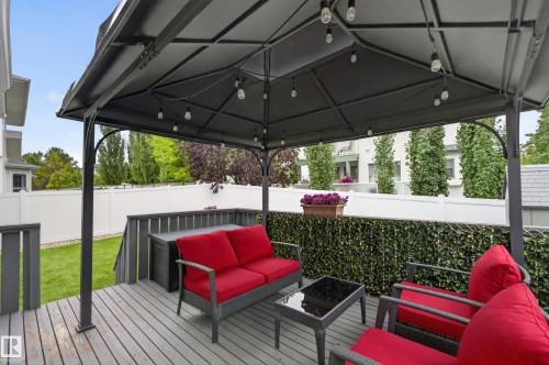 Outdoor deck with a dark gray gazebo featuring string lighting, privacy fencing, and a manicured lawn area - 365 Hollick-Kenyon Road Nw, Edmonton, AB 