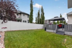 Manicured lawn with a privacy fence, an elevated deck, and a gazebo - 