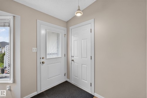Entryway featuring a white door with decorative glass, a solid white door, and a flush-mount ceiling light - 365 Hollick-Kenyon Road Nw, Edmonton, AB 