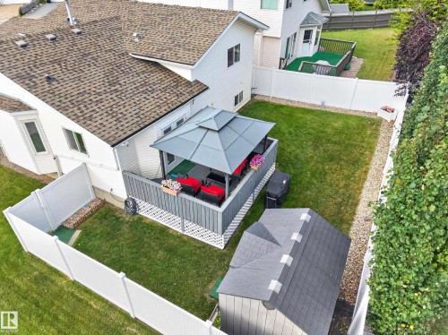 Backyard with a raised deck featuring a gazebo, enclosed by white privacy fencing, and includes a storage shed - 365 Hollick-Kenyon Road Nw, Edmonton, AB 