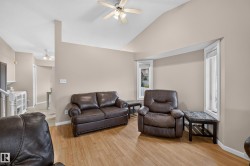 Vaulted ceiling with a ceiling fan, wood-finish flooring, and bay windows - 