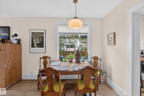 Hardwood-finish flooring, built-in wooden cabinetry, recessed window with white trim, white baseboards, and a globe pendant light fixture - 11308 123 Street Nw, Edmonton, AB 