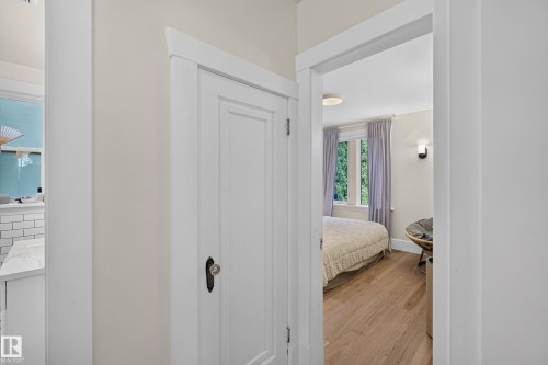 Wood-finish flooring, white walls, white trim, and a built-in wall sconce - 11308 123 Street Nw, Edmonton, AB 