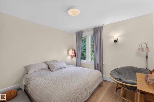 Light wood-finish flooring, a flush-mount ceiling light, and a wall-mounted sconce - 11308 123 Street Nw, Edmonton, AB 