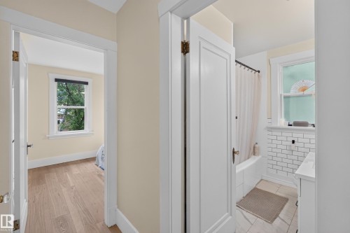 Hardwood flooring, white trim, single window, white paneled door, white subway tile - 11308 123 Street Nw, Edmonton, AB 