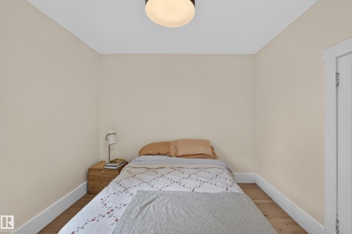 Wood-finish flooring, light neutral wall color, and a flush mount ceiling light fixture - 11308 123 Street Nw, Edmonton, AB 