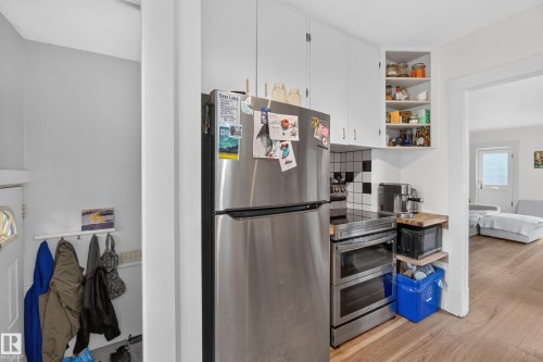White cabinetry with corner shelving, stainless steel appliances, and wood-finish flooring - 11308 123 Street Nw, Edmonton, AB 