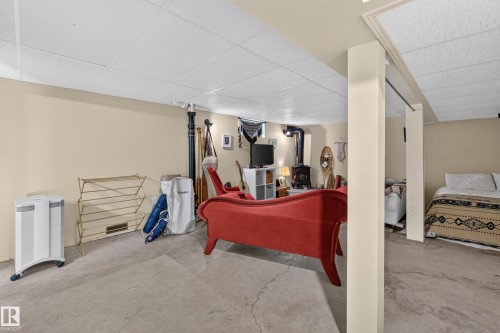 Finished concrete flooring with painted walls, exposed support beams, and a drop ceiling - 11308 123 Street Nw, Edmonton, AB 