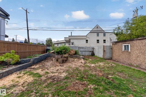 Yard space featuring a wood fence, a retaining wall, a storage shed, and a wooden gate - 11308 123 Street Nw, Edmonton, AB 