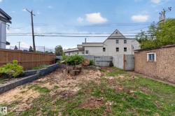 Yard space featuring a wood fence, a retaining wall, a storage shed, and a wooden gate - 