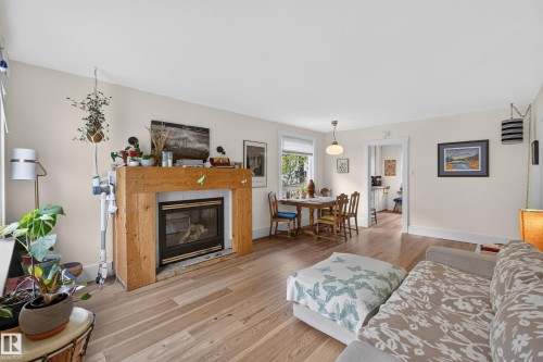 Hardwood flooring, natural wood fireplace mantel, fireplace insert, recessed lighting, and a white trim window - 11308 123 Street Nw, Edmonton, AB 