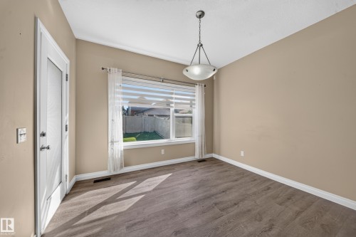 Wood-finish flooring, white trim, and a contemporary ceiling fixture - 121 64 Street Sw, Edmonton, AB 