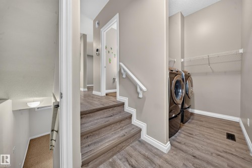 Wood-finish flooring throughout, featuring a built-in laundry area with shelving - 121 64 Street Sw, Edmonton, AB 