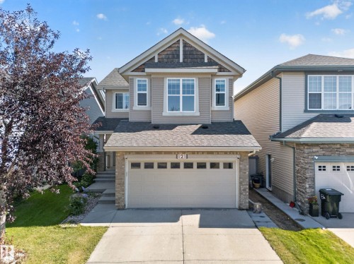 Two-story exterior with a gabled roof, stone accents, attached two-car garage, and concrete driveway - 121 64 Street Sw, Edmonton, AB 