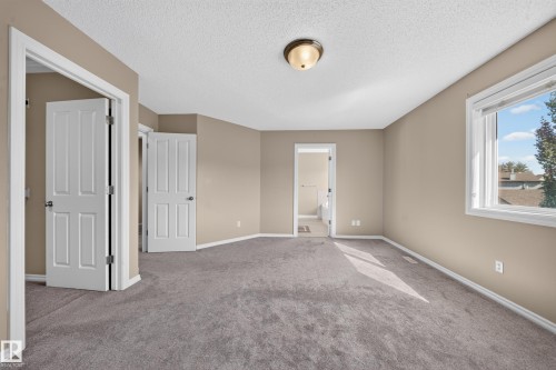 Spacious room featuring gray carpeting, neutral-toned walls, and a recessed window with white trim - 121 64 Street Sw, Edmonton, AB 