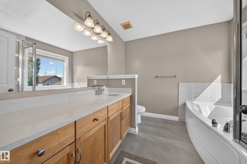 Dual vanity with light-toned countertops and natural wood cabinetry - 121 64 Street Sw, Edmonton, AB 