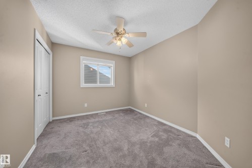 Vaulted ceiling with a ceiling fan, neutral wall paint, white trim, gray carpet, and a window with blinds - 121 64 Street Sw, Edmonton, AB 