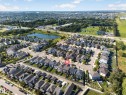 Aerial perspective showcasing a residential neighborhood with varied architectural styles, a central water feature, and mature landscaping - 121 64 Street Sw, Edmonton, AB 