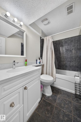 White vanity with chrome hardware, an integrated sink, and a single-handle faucet - 121 64 Street Sw, Edmonton, AB 