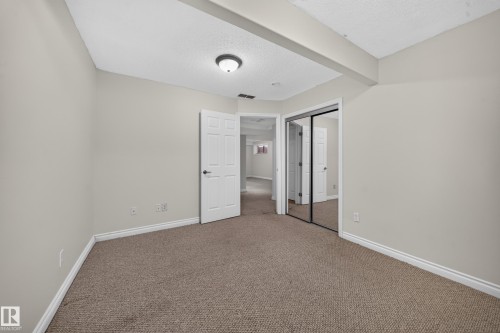 Neutral-toned walls complement plush carpet flooring - 121 64 Street Sw, Edmonton, AB 
