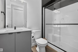 Contemporary bathroom featuring a grey vanity with an integrated sink and matte black faucet - 