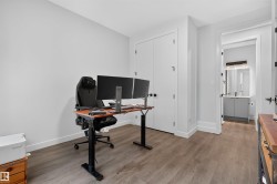 Spacious room featuring wood-finish flooring and light-toned walls - 