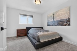 Light-filled room featuring a window with roller shade, neutral carpeting, white baseboards, and a flush-mount ceiling light - 