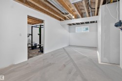 Unfinished basement space featuring exposed ceiling joists and plumbing - 