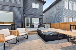 Expansive multi-level composite deck featuring an integrated spa, durable black railing, and direct home access - 