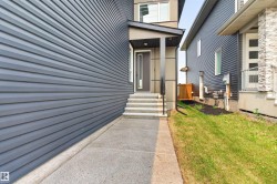 Modern exterior featuring dark gray horizontal siding and a covered entry - 