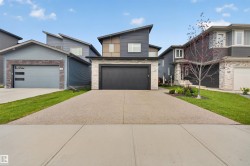 Contemporary exterior featuring a black garage door and stone veneer detailing - 