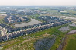 Residential development featuring multiple properties with dark roofs and light-colored siding - 