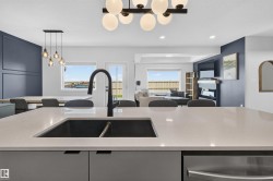 Expansive kitchen island featuring an undermount double sink with a matte black gooseneck faucet - 