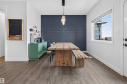 Dining area featuring a wood-finish floor, a large window, and a built-in sideboard - 