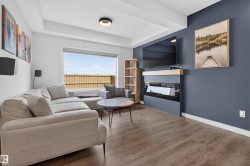 Living area featuring a floor-to-ceiling accent wall with a built-in fireplace and wood-finish mantle - 