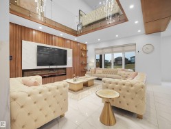High ceilings with recessed lighting, large windows with roller shades, white tile flooring, wood-paneled accent wall with built-in shelving, and a linear electric fireplace - 