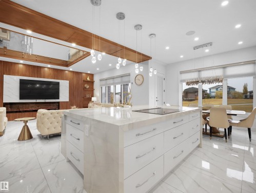 Large center island with a cooktop, white cabinetry, and a stone countertop - 4809 Woolsey Lane Nw, Edmonton, AB 