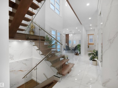 Floating wood staircase with glass railing and stainless steel accents - 4809 Woolsey Lane Nw, Edmonton, AB 
