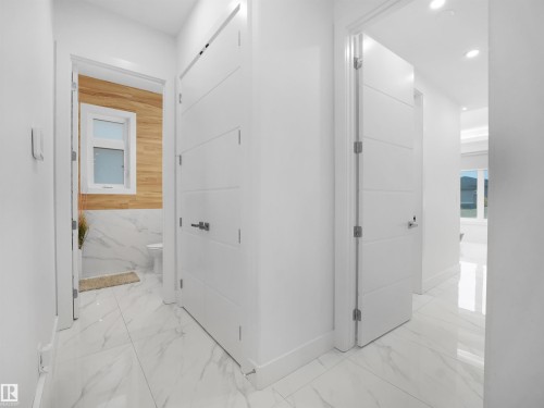 White paneled doors with contemporary hardware, recessed ceiling lighting, and reflective tile flooring - 4809 Woolsey Lane Nw, Edmonton, AB 