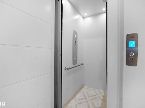 Built-in residential elevator with a brushed metal control panel and recessed ceiling lighting - 4809 Woolsey Lane Nw, Edmonton, AB 