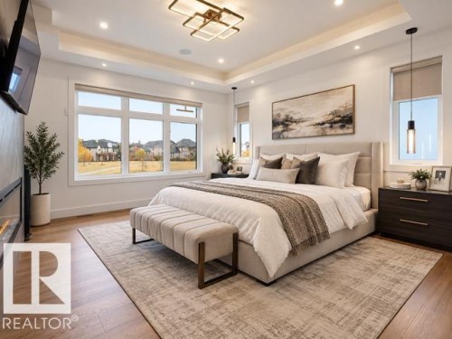 Recessed lighting, wood-finish flooring, a built-in electric fireplace, and large windows with roller shades - 4809 Woolsey Lane Nw, Edmonton, AB 