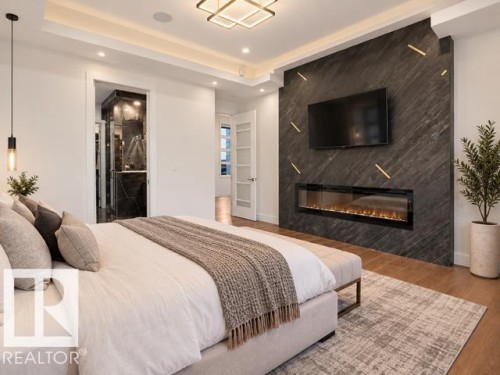 Wall-mounted linear fireplace within a dark stone-clad accent wall - 4809 Woolsey Lane Nw, Edmonton, AB 