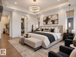 Tray ceiling with recessed lighting and a central chandelier - 