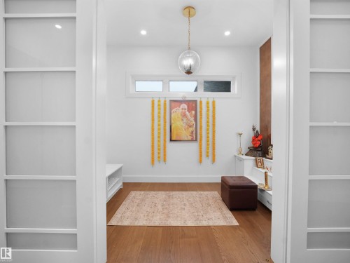 Hardwood-finish flooring, recessed lighting, and a clear globe pendant light - 4809 Woolsey Lane Nw, Edmonton, AB 