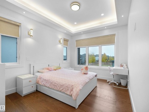 Recessed lighting, tray ceiling, hard surface flooring, multiple windows, and wall sconces - 4809 Woolsey Lane Nw, Edmonton, AB 