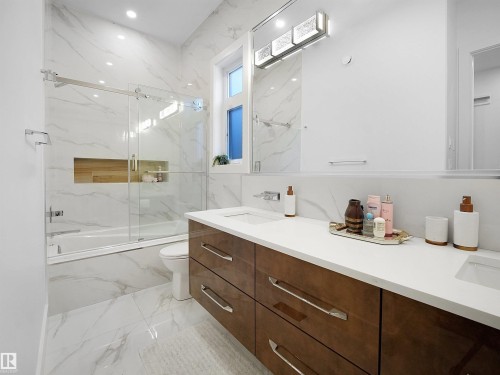 White marble-patterned tile flooring and wall surround a built-in tub with a sliding glass door - 4809 Woolsey Lane Nw, Edmonton, AB 