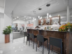 Expansive wet bar with a glossy wood-finish bar and overhead display cabinetry - 